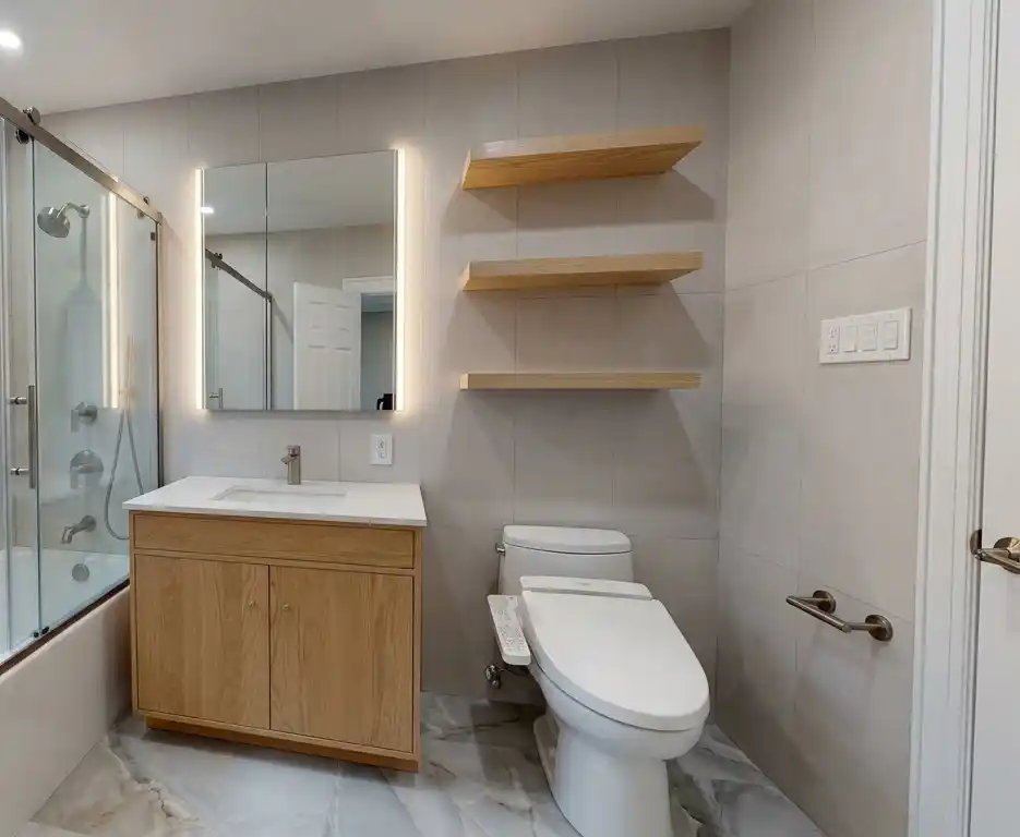 This modern bathroom remodel incorporated high-end finishes and thoughtful design choices to create a sleek and functional space. The project involved the installation of a new lighted medicine cabinet, a custom tub/shower, frame-out built-in shelving, and a japanese smart toilet, making the bathroom both elegant and highly practical | Batroom Remodel | East 21 Street, Brooklyn NY | DCON Renovations New York - Brooklyn | Remodeling - Architectural Design - Residential Contractor - Brownstoner Experts