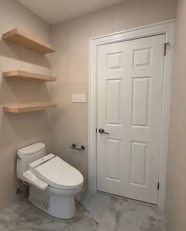 This modern bathroom remodel incorporated high-end finishes and thoughtful design choices to create a sleek and functional space. The project involved the installation of a new lighted medicine cabinet, a custom tub/shower, frame-out built-in shelving, and a japanese smart toilet, making the bathroom both elegant and highly practical | Batroom Remodel | East 21 Street, Brooklyn NY | DCON Renovations New York - Brooklyn | Remodeling - Architectural Design - Residential Contractor - Brownstoner Experts